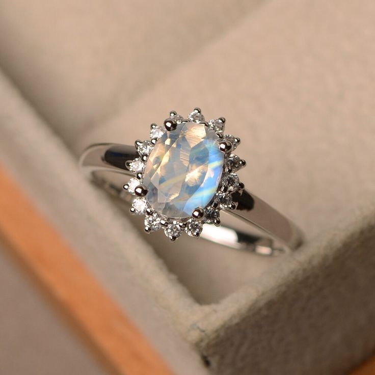 This ring features a 6*8mm oval cut moonstone and sterling silver finished with rhodium. Customization is available. It is made by hand, and it will take about 7 days to finish the ring after your payment is completed. Main stone: 6*8mm oval cut Moonstone Moonstone weight: Approx 1.2 ct Metal type: sterling silver finished with rhodium, 14k white/yellow/rose gold Accent stone: cz Customization is available, I also can make it with 14k solid gold (white or yellow or rose) and diamond accent stone Weddings Ring, Engagement Ring Halo, Jewelry Certificate, Engagement Ring Photos, Handmade Jewelry Ring, Jewellery Ring, Moonstone Engagement, Moonstone Engagement Ring, Ring Halo