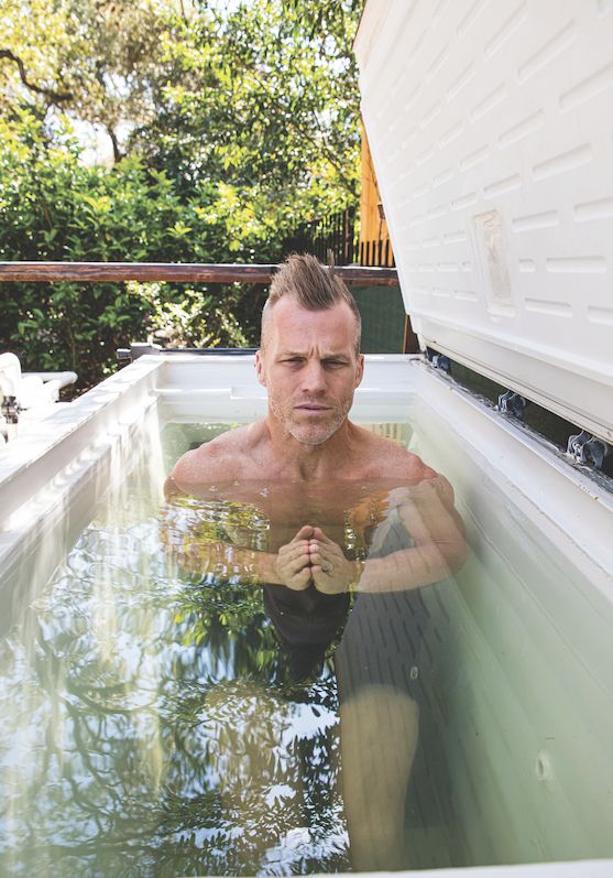 a man sitting in the middle of a swimming pool with his hands on his chest