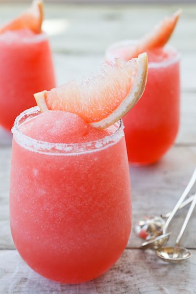 two glasses filled with watermelon margaritas and garnished with grapefruit