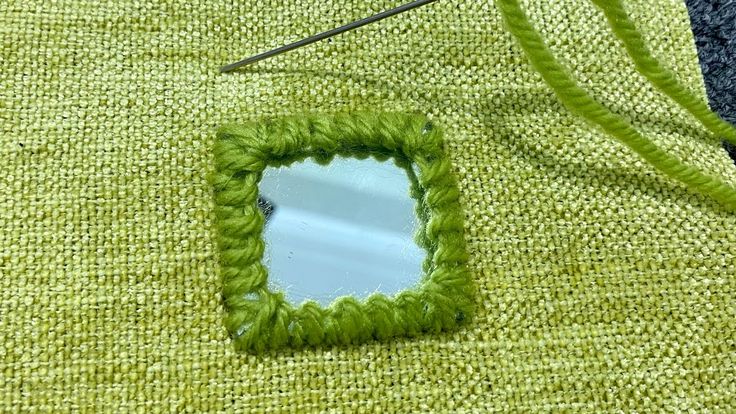 a green piece of yarn with a mirror on it