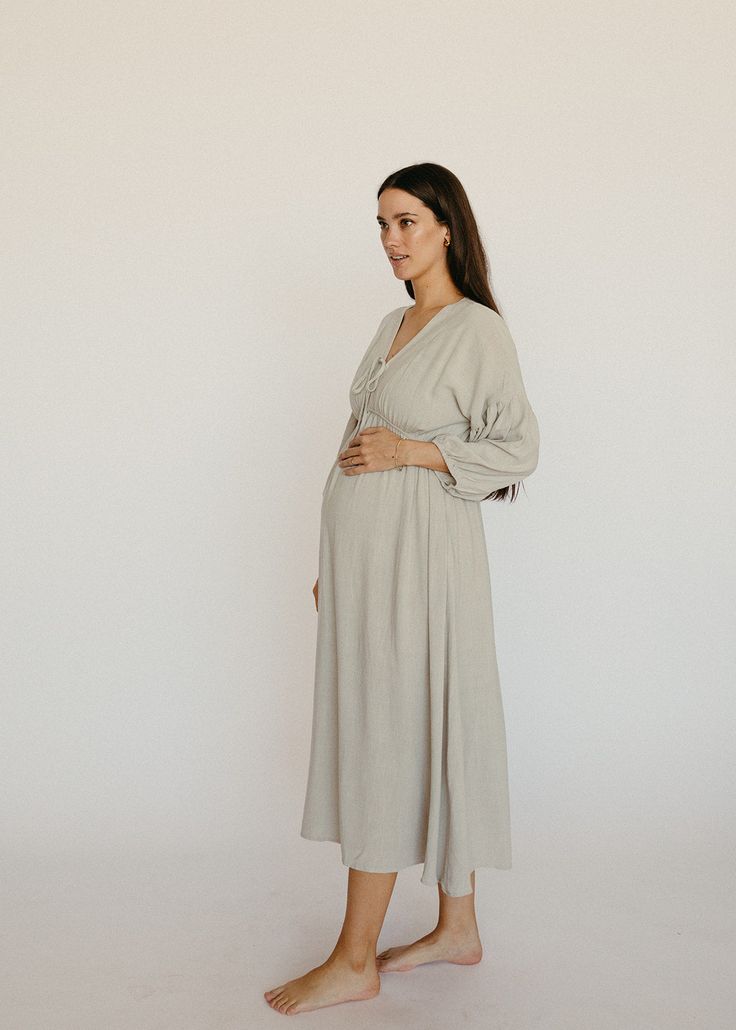 Pregnancy, postpartum and nursing - this dress does it all! This linen midi dress is light and flowy, it pairs beautifully with a bump and is nursing friendly. The soft grey color, front tie detail and peasant sleeve are understated feminine details. You'll feel like you're the star of your own Nancy Meyers movie in this dress. Sizing: XS : 0-2 Small : 4-6 Medium : 8-10 Large : 12 XLarge : 14 Maternity Night Dress, Peasant Sleeve Dress, Maternity Dresses Modest, Winter Baby Shower Dress For Mom, Nursing Friendly Dress For Wedding, Modest Pregnancy Outfits, Maturity Clothes, Cute Pregnancy Outfits, Maternity Occasion Wear