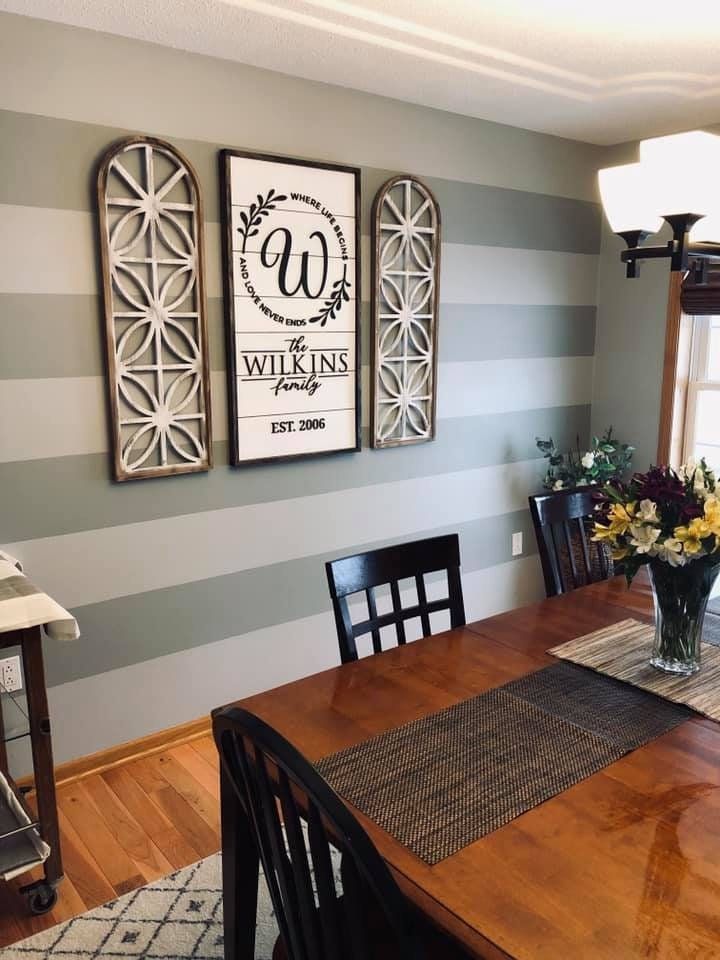 the dining room table is set with flowers in a vase and two framed pictures on the wall