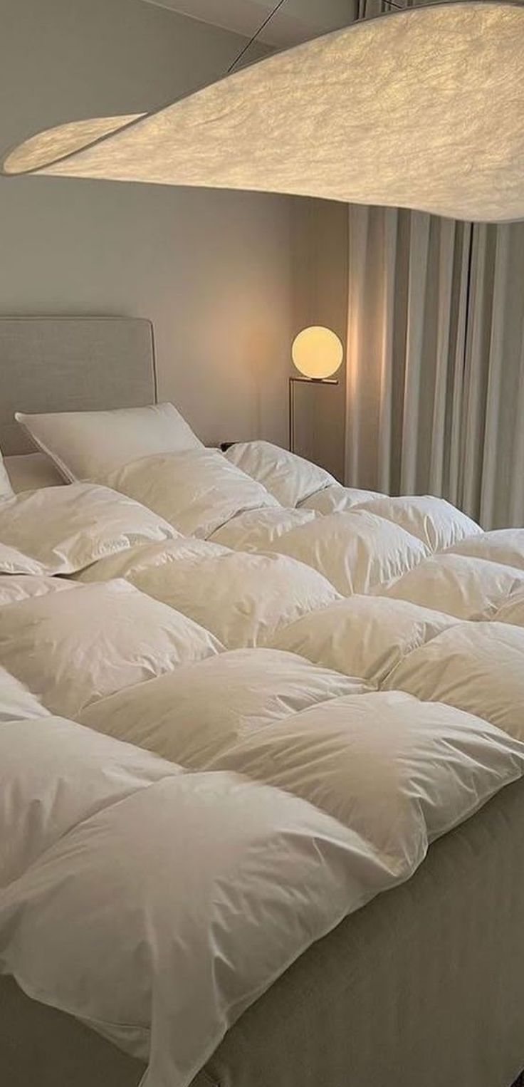 an unmade bed with white sheets and pillows