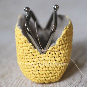 a close up of a knitted object with scissors in it's holder on a table