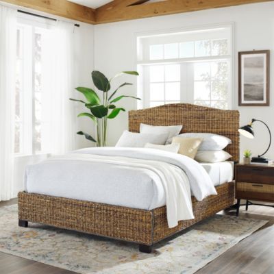 a bed with white linens and pillows in a room next to a large window