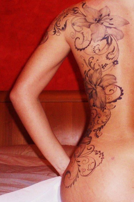 the back of a woman's body with tattoos on it