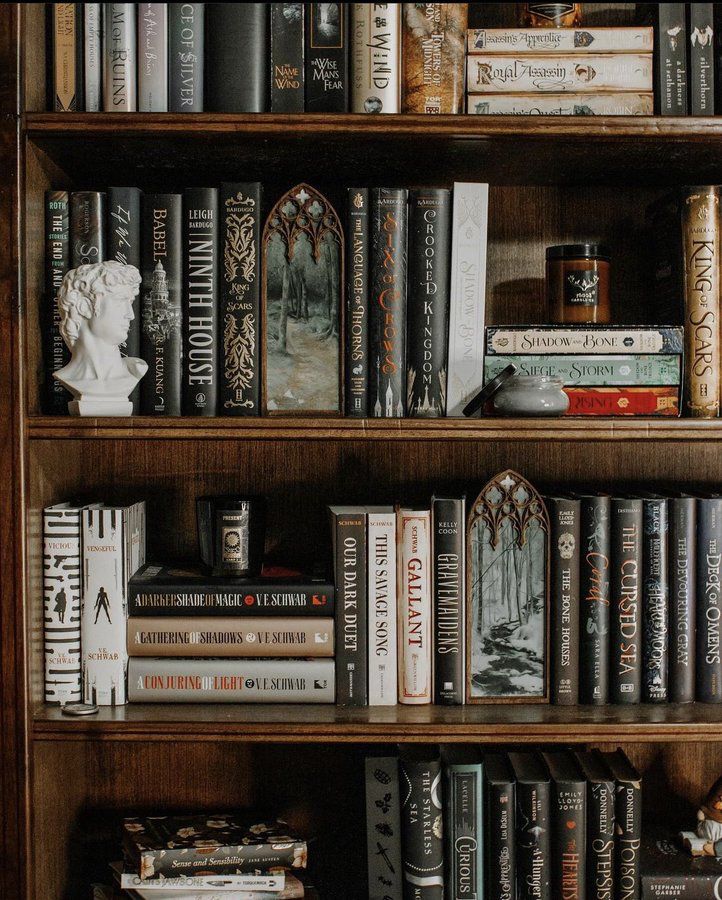 a book shelf filled with lots of books on top of wooden shelves next to each other