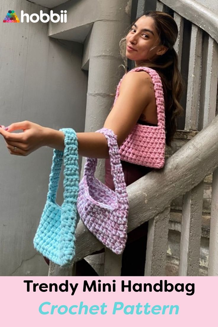 a woman is holding two crocheted purses on the handrail, while looking off into the distance