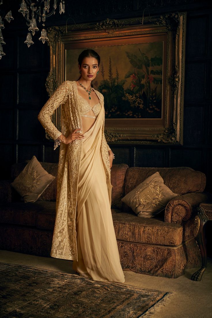 This fuss free pre-draped georgette saree comes with an attached petticoat. The strappy blouse is fully embroidered in dori, pearl and sequin. The saree has a flattering silhouette. The accompanying front open jacket features fully embroidered in dori, pearl and sequin in an abstract pattern The sleeve hem and saree palla show exaggerated tassels.From Seema Gujral's Kashish collection DELIVERY TIMEPlease allow 8-12 weeks for your outfit to arrive. FABRIC DETAILSSaree -Georgette, Jacket- Net Prof Jacket Saree, Saree Aesthetic, Falooda Recipe, Strappy Blouse, Saree Jacket, Seema Gujral, Saree Jackets, Drape Saree, Open Jacket