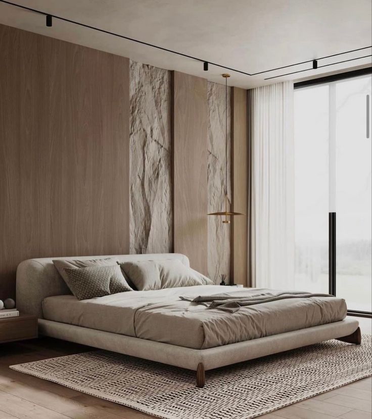 a large bed sitting on top of a wooden floor next to a window in a bedroom