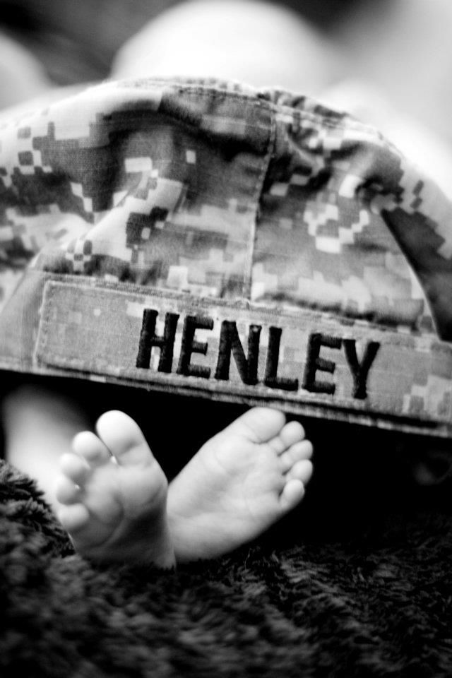 a black and white photo of a baby wearing a hat with the word henley on it