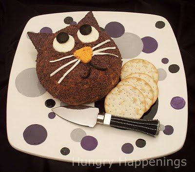 a cake shaped like a cat and crackers on a plate with polka dot design