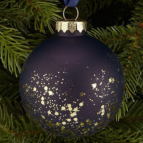 a blue ornament hanging from a christmas tree with gold speckles on it