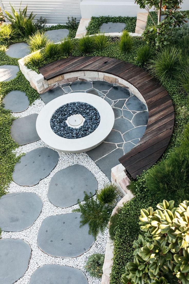 a circular bench sitting in the middle of a garden