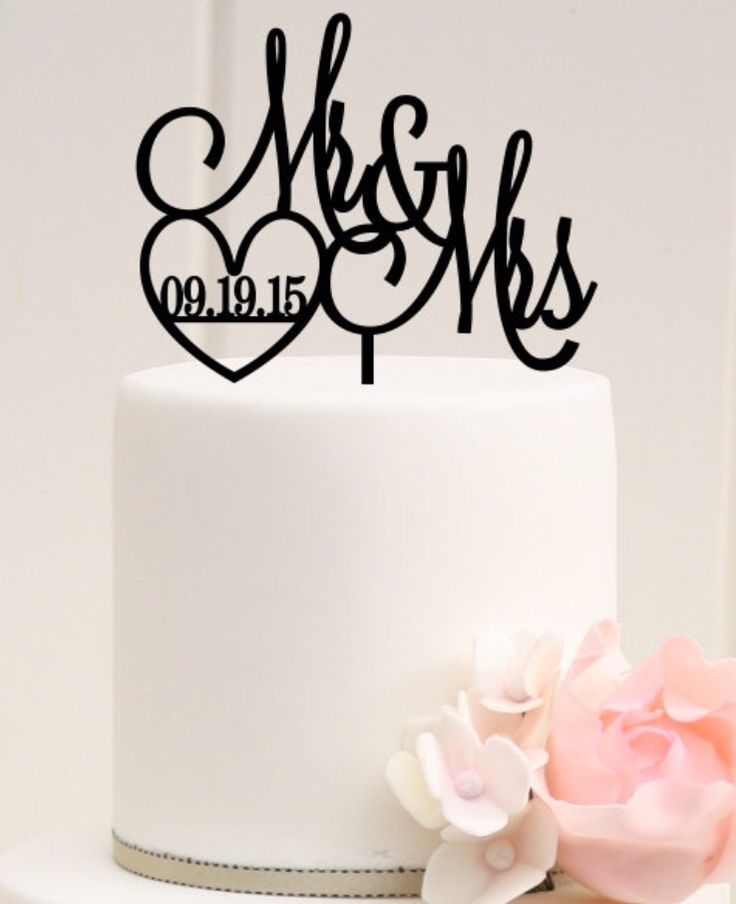 a white cake topped with a couple's initials and flowers on top of it