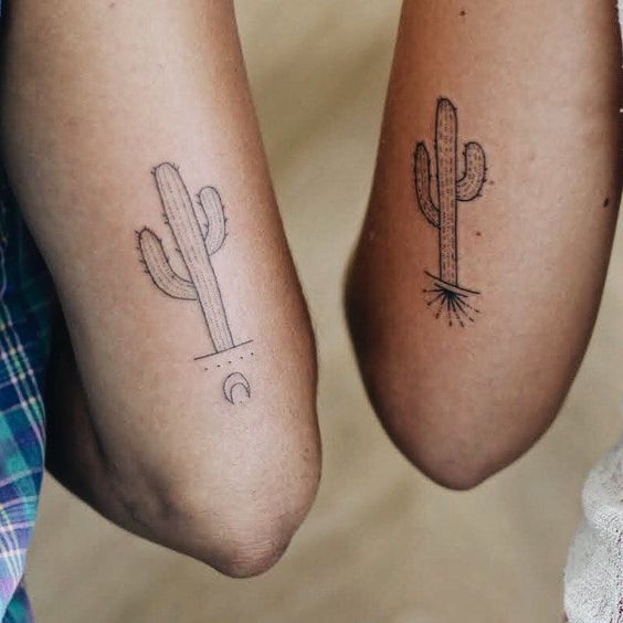 two people with matching tattoos on their legs, one has a cactus and the other has a moon