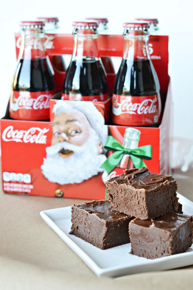 coca - cola and brownies on a white plate with santa claus in the background