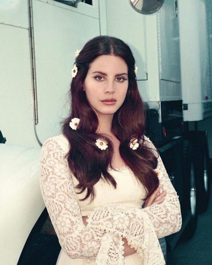 a woman with long dark hair and flowers in her hair is posing for the camera