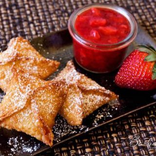 some food is on a black plate with strawberries