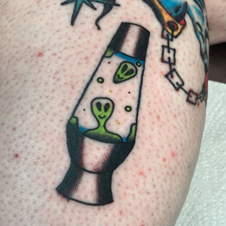 a person with a tattoo on their arm has an image of a spaceship and alien