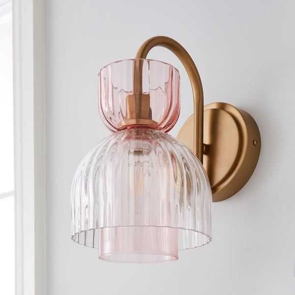 a pink glass light fixture on a white wall