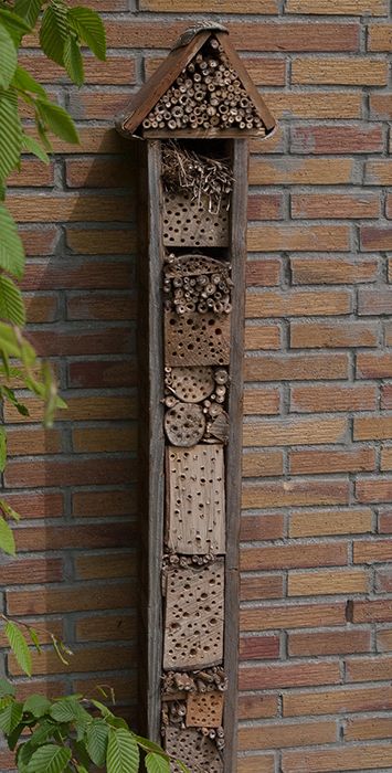 a bird house hanging on the side of a brick wall