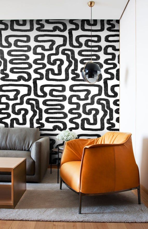 a living room with black and white wallpaper, leather chairs and a coffee table