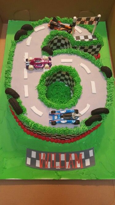 a birthday cake made to look like a race track with cars on the tracks and grass