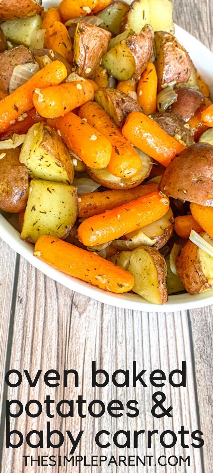 oven baked potatoes and baby carrots in a white bowl on top of a wooden table