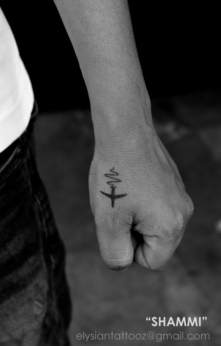 a person's hand with a small tattoo on their left thumb and an anchor in the middle