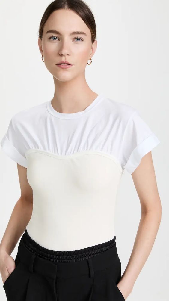 Elevate your date night look with the A.L.C. Frankie Tee in white. This sleek and chic top features a slim fit design with ruching at the bustier-inspired seam and a crew neckline, providing a flattering silhouette. The short sleeves have fixed cuffs for added style. Made with lightweight jersey material and a mix of 95% cotton and 5% elastane, this top is comfortable and easy to wear all night long. Shopbop affiliate #DateNightTop #ALC #FrankieTee #SingleWomenFashion #SummerFashion Night Tops, Chic Top, Corset Style, Date Outfits, Denim Wash, White Undershirt, New Arrivals, Summer Fashion, Short Sleeves