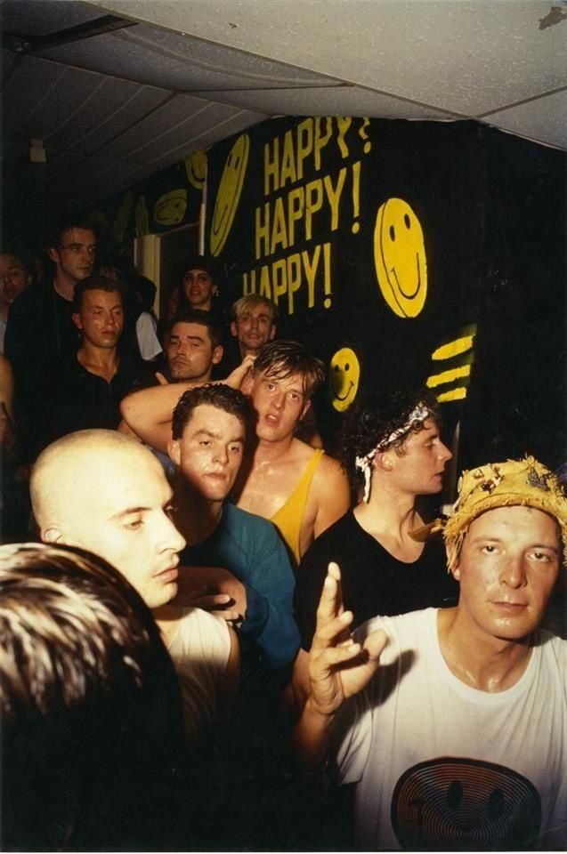 a group of young men standing next to each other in front of a happy sign