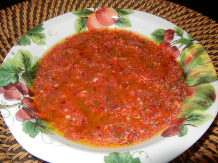 a white plate topped with red sauce on top of a table