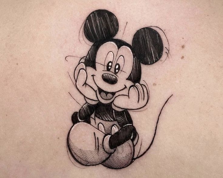 the back of a woman's shoulder with a cartoon mickey mouse tattoo on it