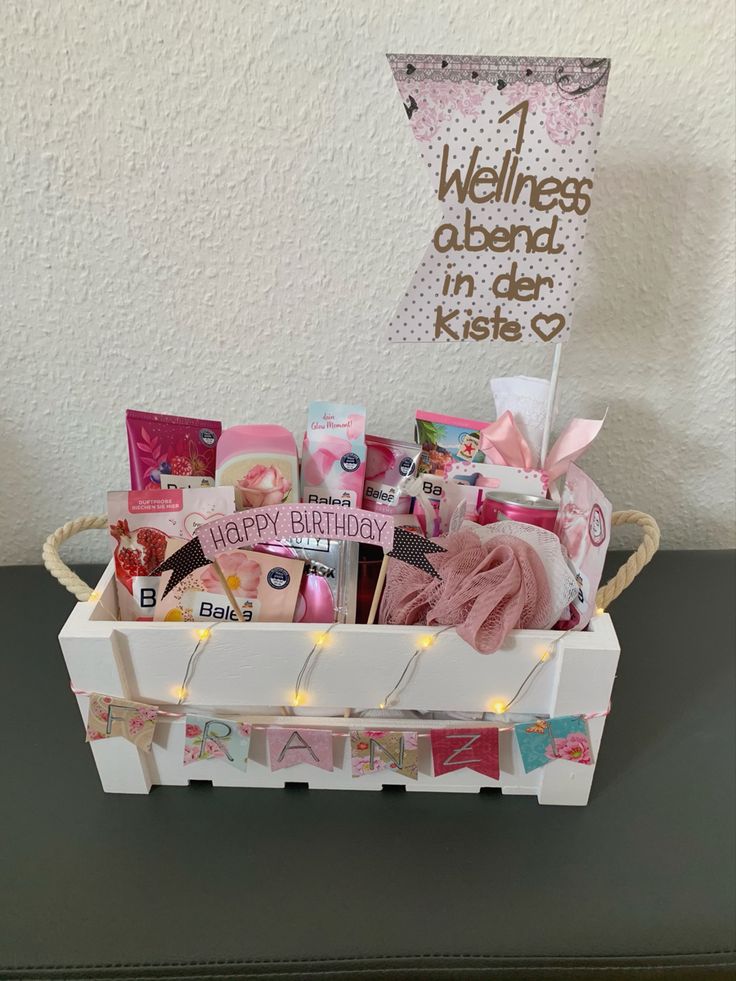 a white basket filled with lots of items on top of a table next to a sign