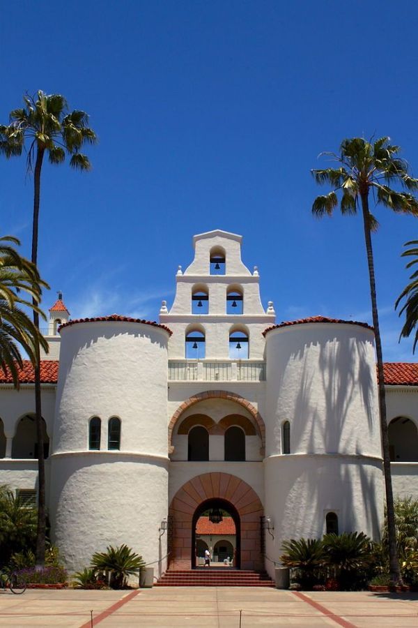 a large white building surrounded by palm trees