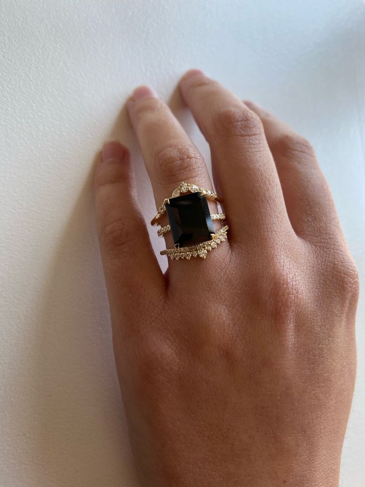 The big sister to our beloved Onyx Ring. A 5.5ct emerald cut Black Onyx is set into our signature claw prongs for a dramatic effect. The subtle, flat quarter band with 0.09tcw of Diamonds gives this piece its modern feel with just the right amount of shine. This ring will certainly turn heads! Treat with love due to the center stone softness. Band width, 1.5mm. Pictured on a size 4 finger. Can't wait? Check out our Ready To Ship pieces or send us a message! Ring Black Stone, Onyx Engagement Ring, Claw Prong, Black Onyx Ring, Put A Ring On It, Dress Rings, Onyx Ring, Baguette Diamond, Big Sister