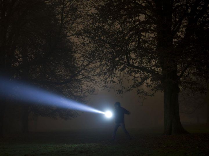 a person with a flashlight in the dark