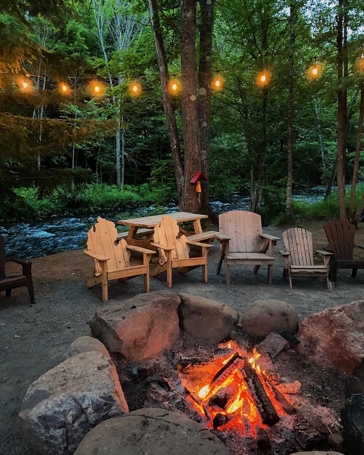 Fire pit along the waters edge of a rushing river with string lights above to complete the comfortable vibe of the natural surroundings Living On The River, Lake House Fire Pit Ideas, River Inspired Decor, Houses On The River, River Property Ideas, River Lot Ideas, House By A River, Cabin Property Ideas, River Cottage Decorating Ideas