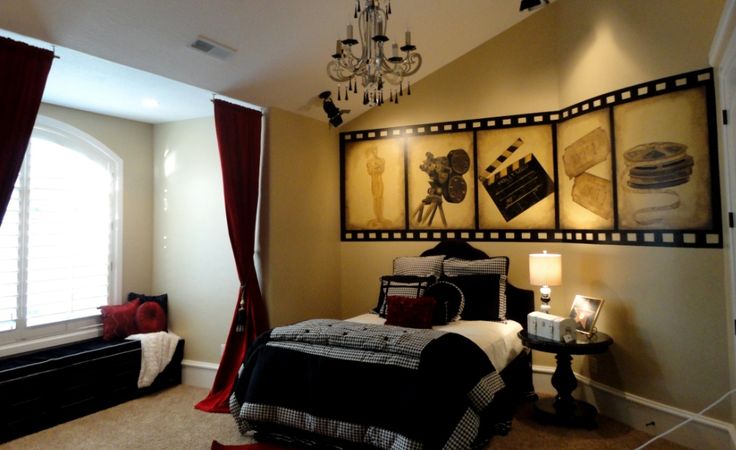 a bedroom with a chandelier hanging from the ceiling and pictures on the wall