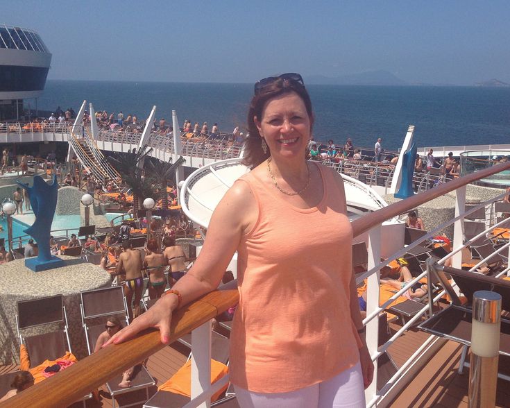 a woman standing on the deck of a cruise ship