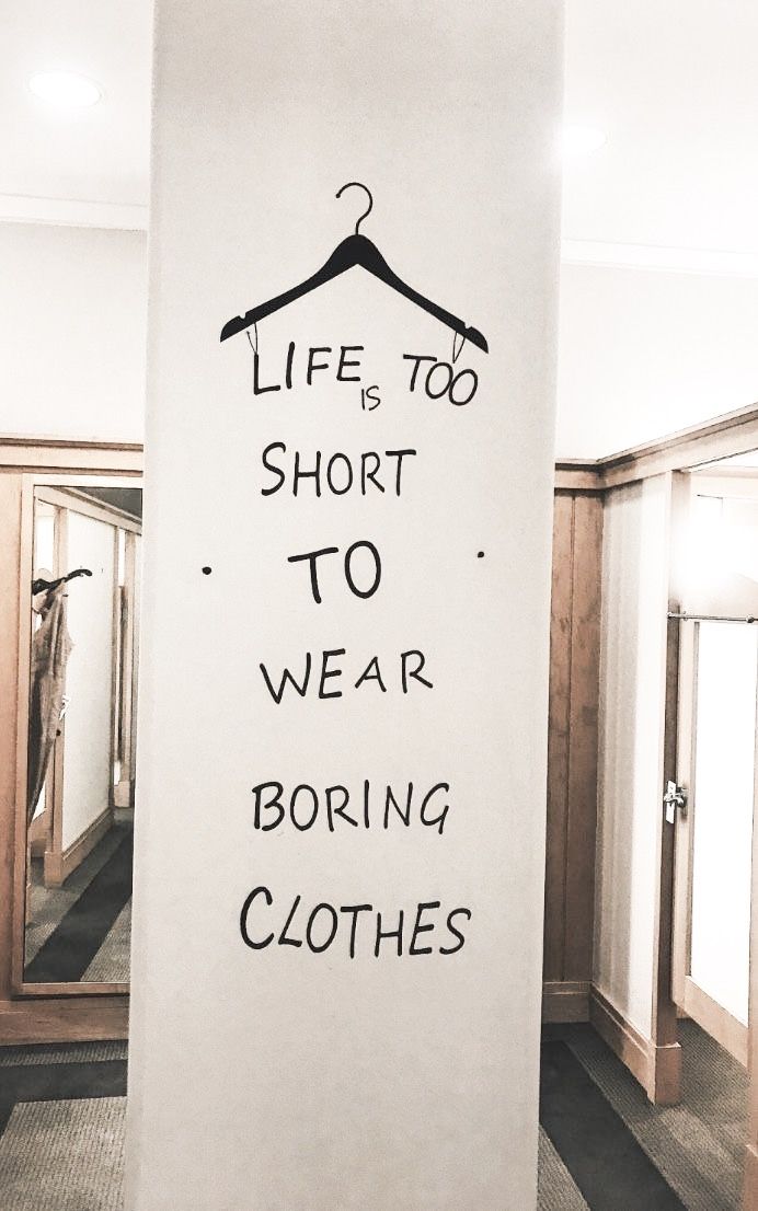 a sign that says life is too short to wear boring clothes hanging on a wall