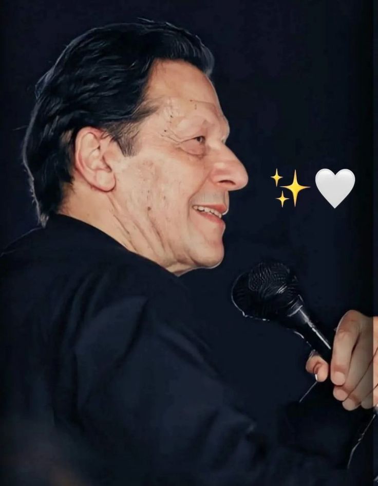 a man holding a microphone in his right hand and smiling at the camera with two hearts above him