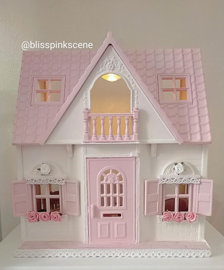 a pink and white doll house on a table