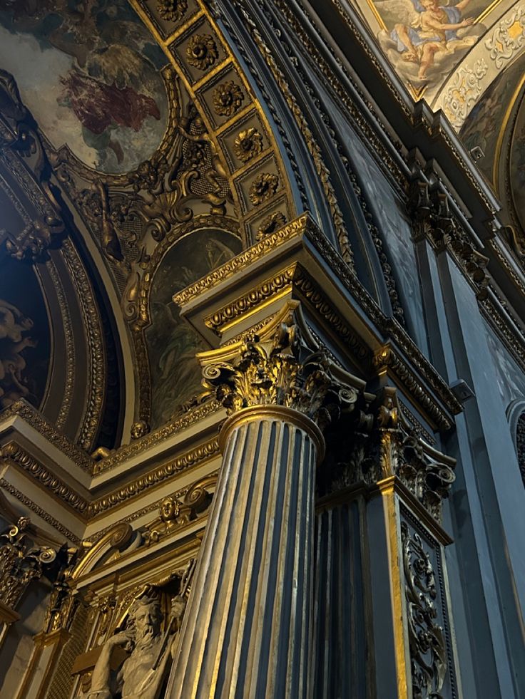 the interior of a church with gold and blue paint on the walls, columns and ceiling