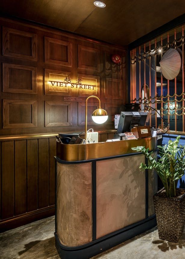 the front desk of a hotel with potted plants