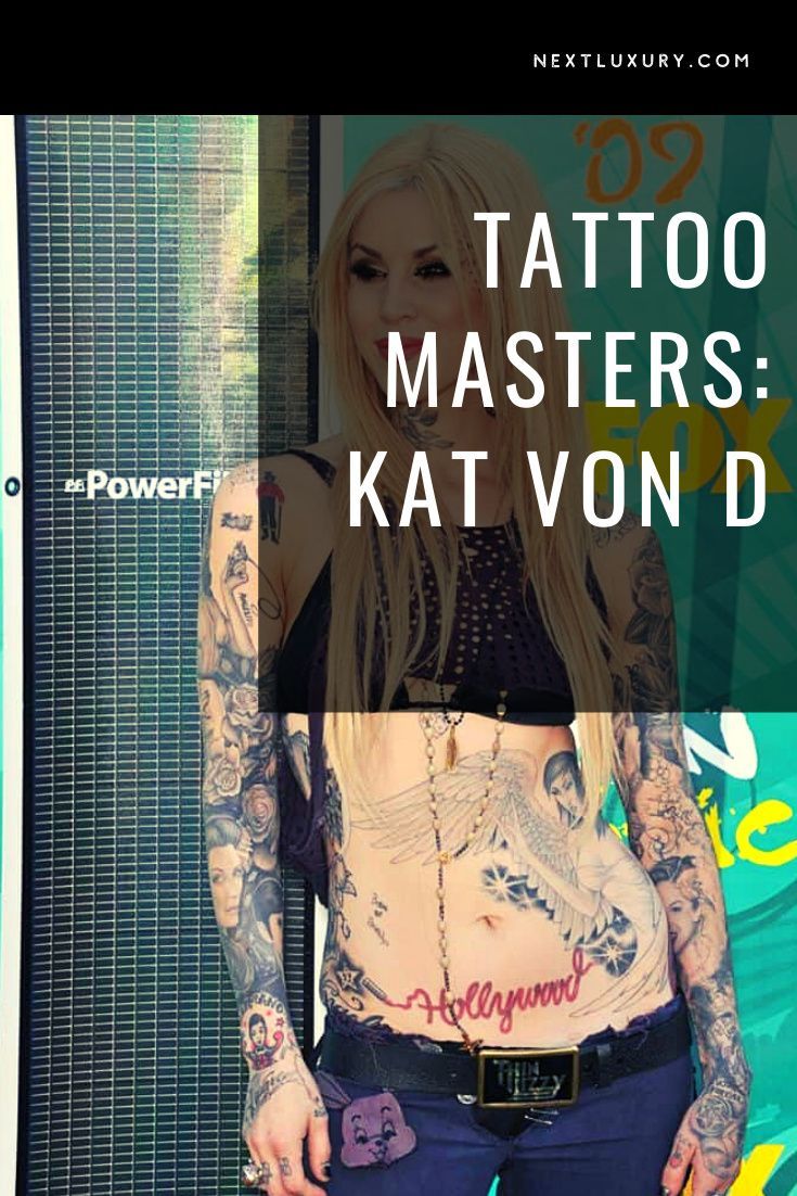 a woman with tattoos standing in front of a sign that says tattoo masters kat von d