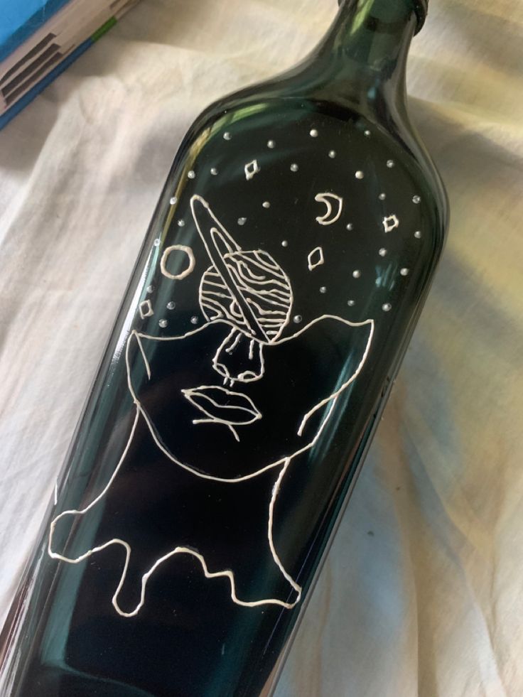 a glass bottle with a drawing on it