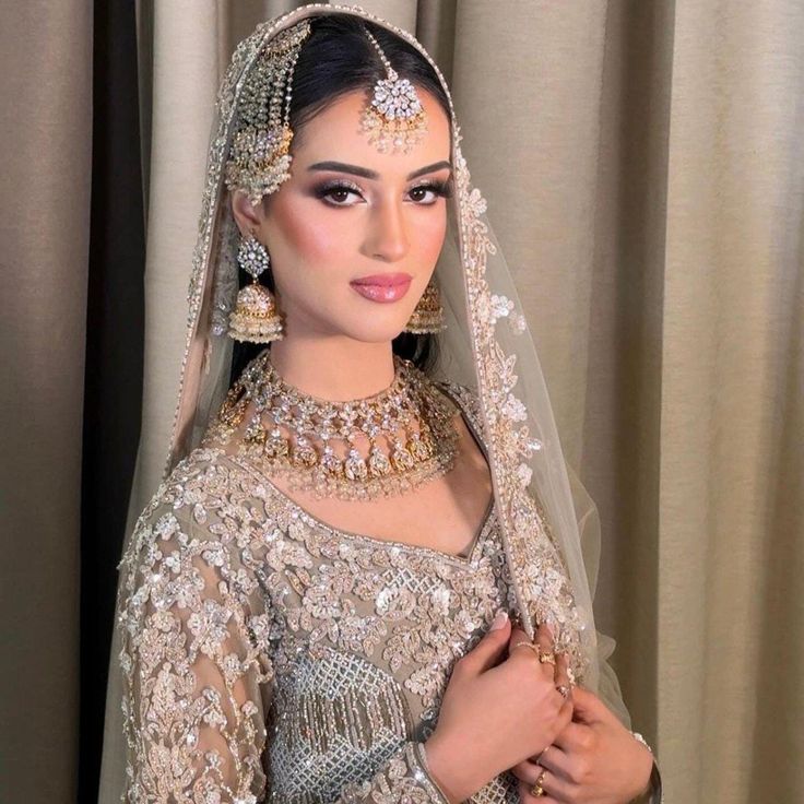 a woman wearing a bridal outfit and jewelry