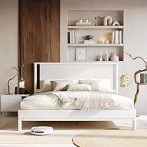 a white bed sitting in a bedroom on top of a hard wood floor next to a book shelf